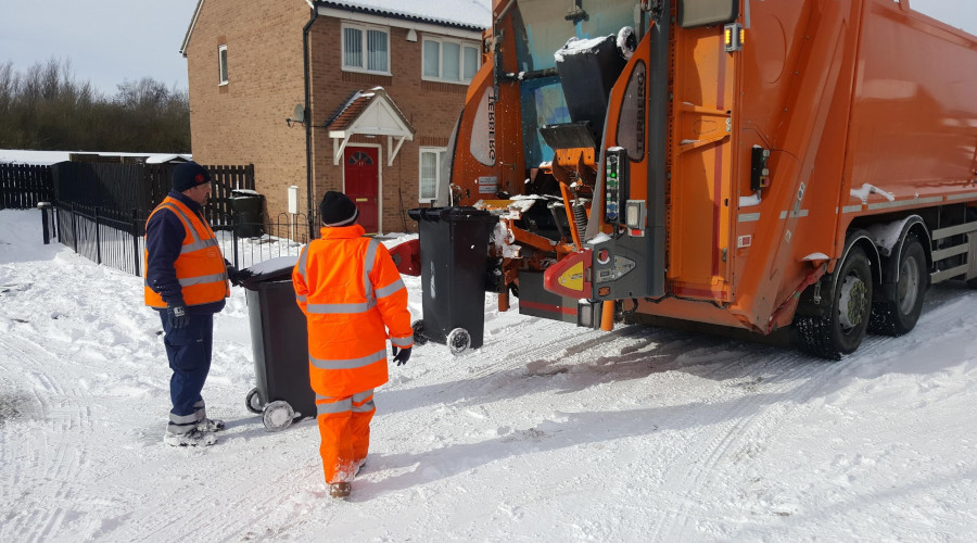 Waste operatives emptying bins in the snow
