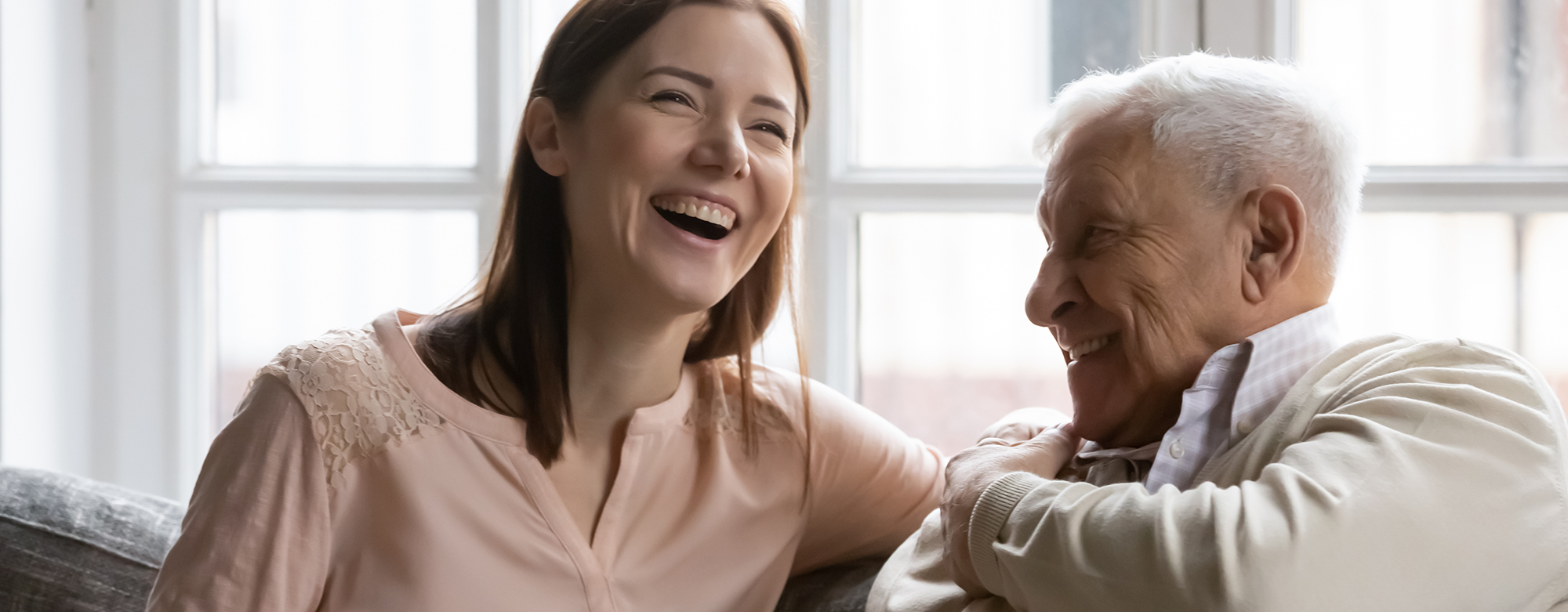 A younger woman and older man laughing together